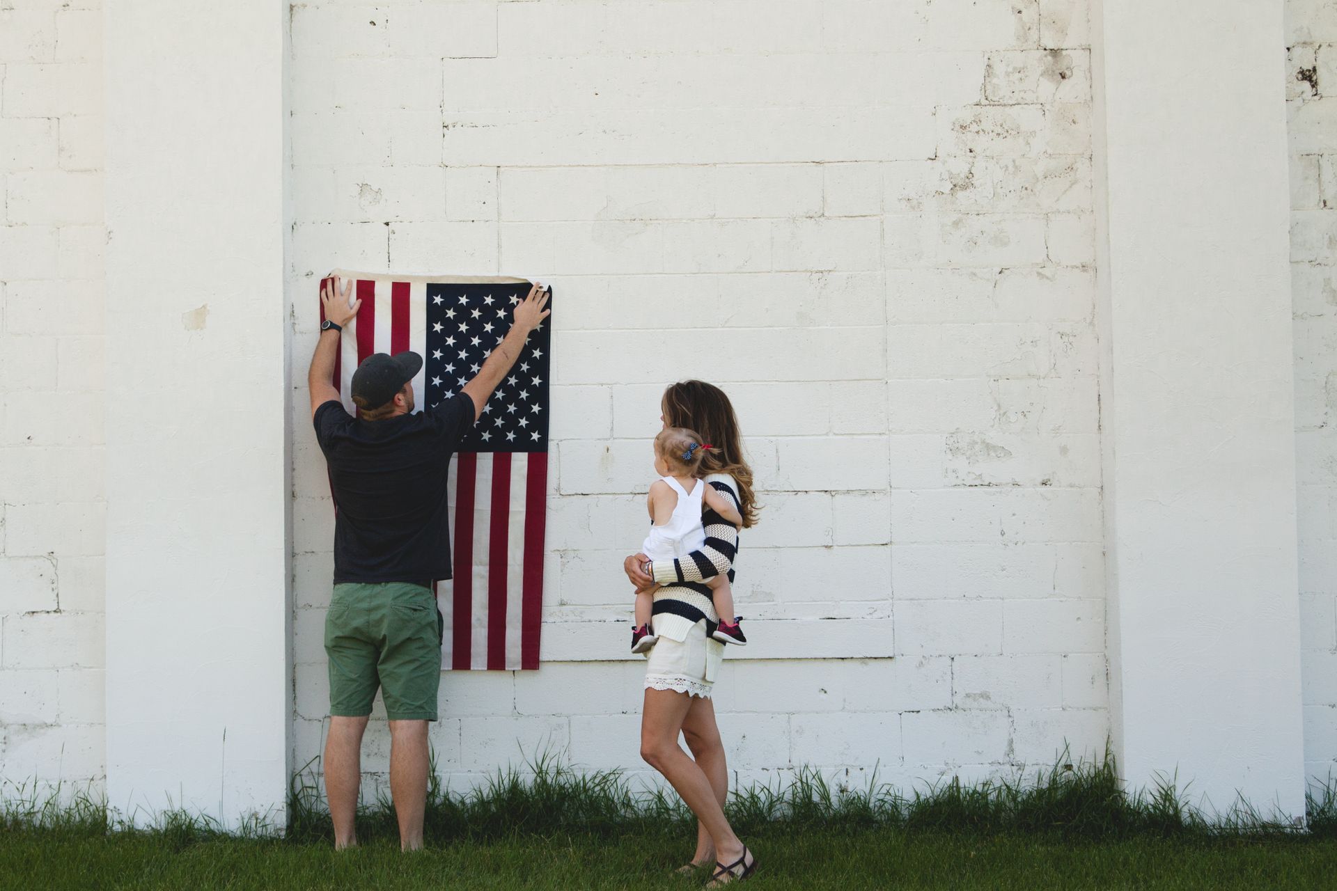 Young family hanging an American flag on their home