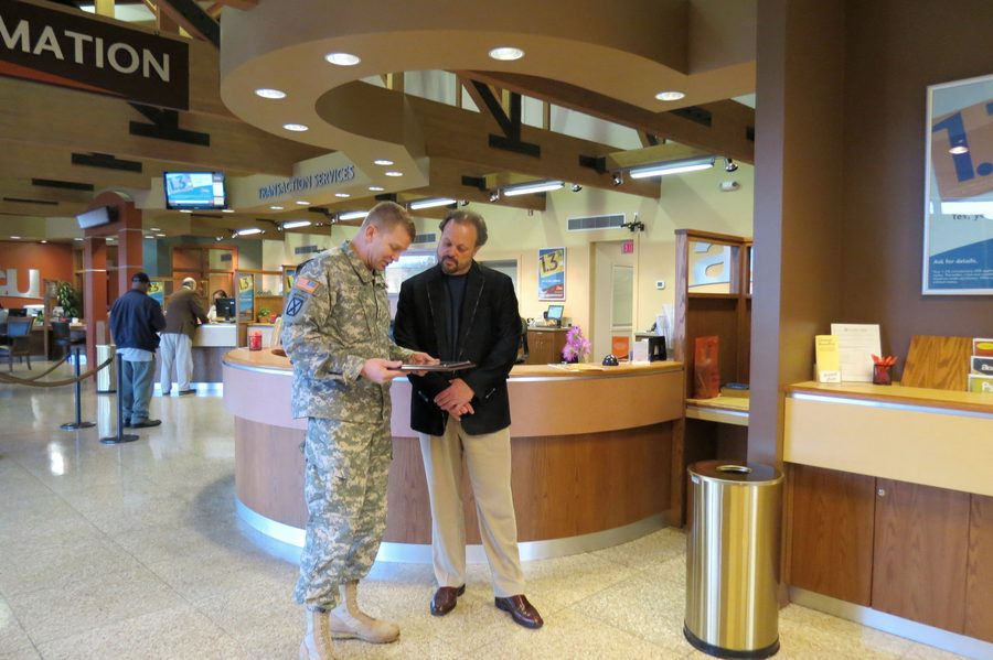 Ken Leonard reviews a document with a uniformed service member inside an ACU branch