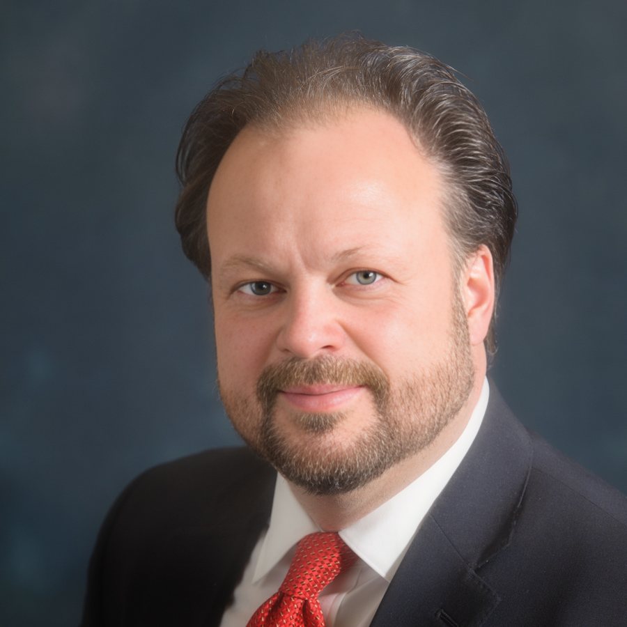Studio portrait of Ken Leonard in a navy suit