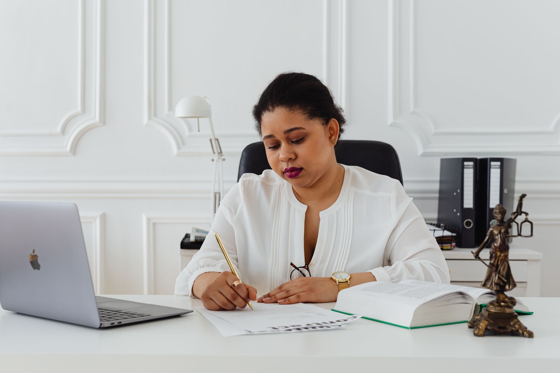 Professional signing official documents at a desk