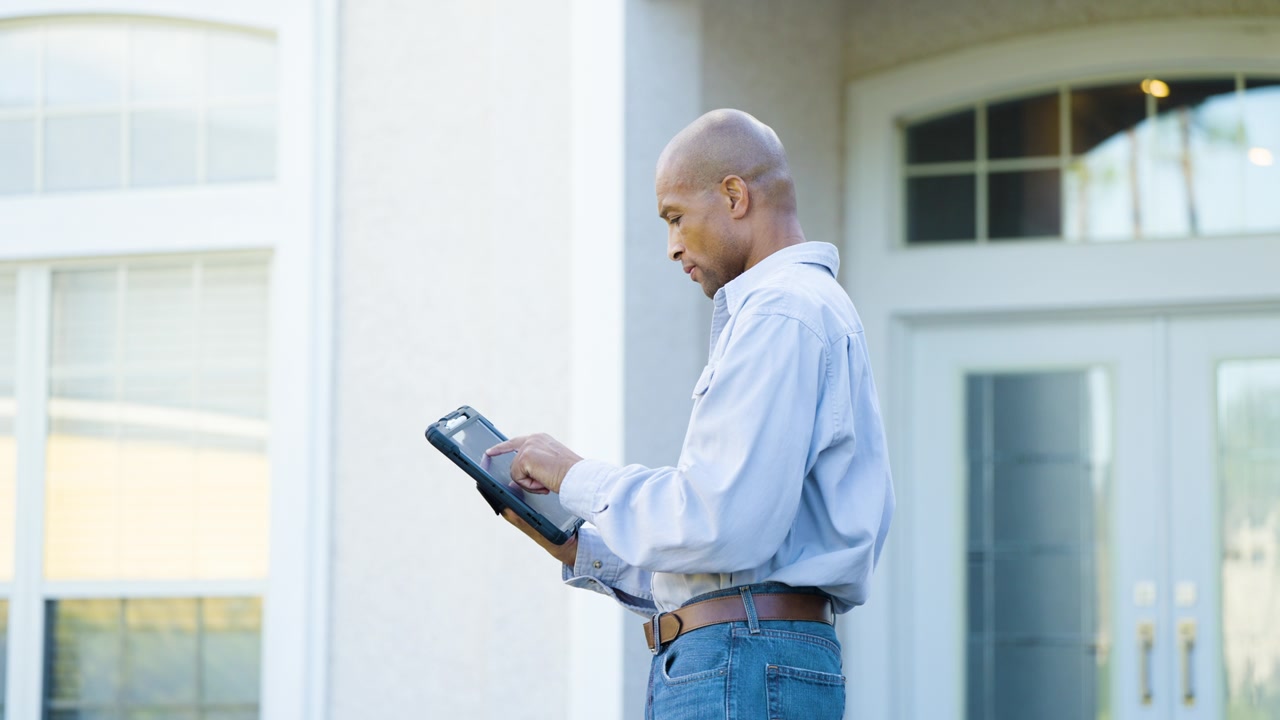 Home inspector examining a house from the front porch