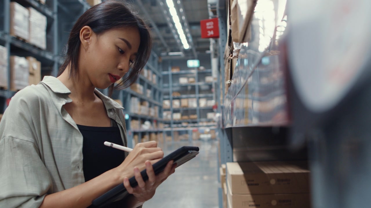 Business owner checking inventory on a tablet in a warehouse