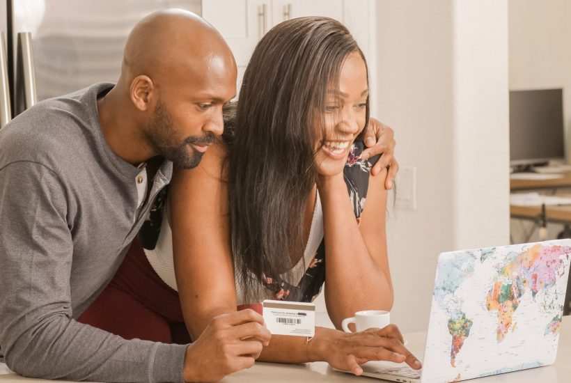 Man and woman smiling and holding a credit card