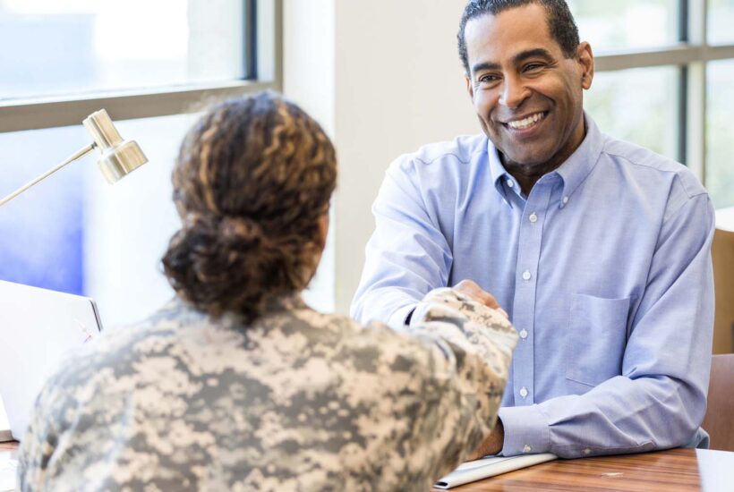 A soldier shaking hands with a friendly staff member.