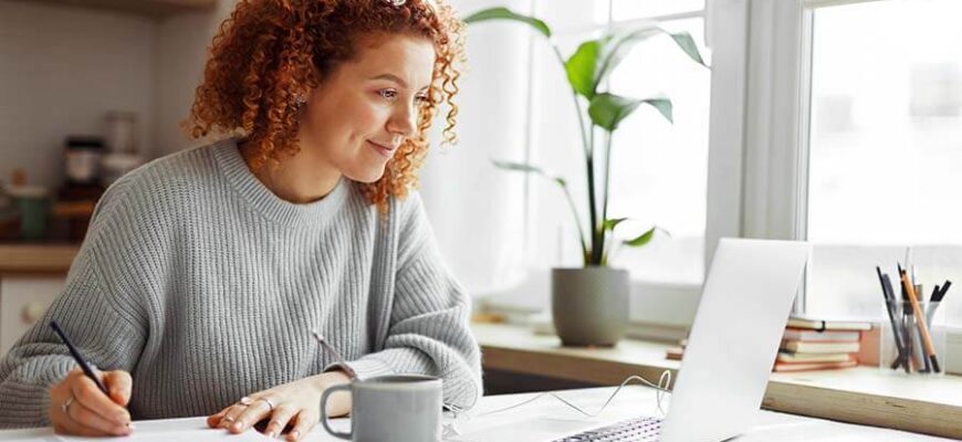 A young woman does research on her laptop about how to join a credit union.