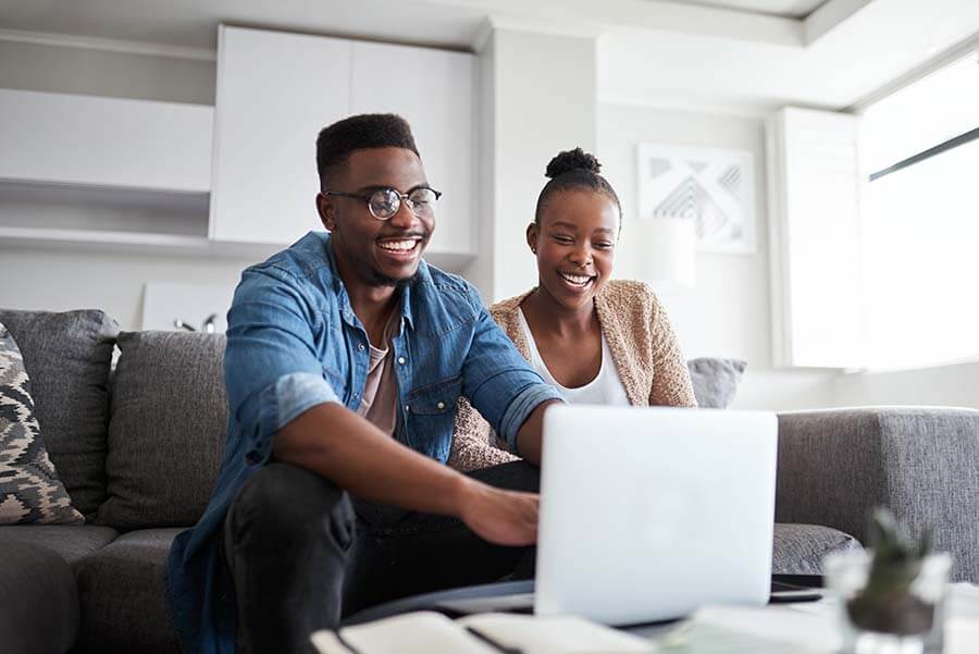 A husband and wife smiling as they see how quick and easy it is to open a Regular Share Savings account online.